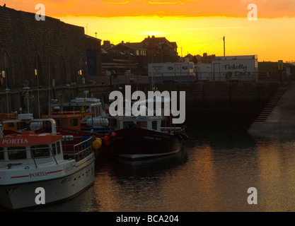 Una profonda golden sunset in porto a Seahouses, Northumberland England Regno Unito Foto Stock