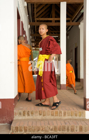 Un monaco novizio inserendo il suo tempio camera scuola a Luang Prabang, Laos Foto Stock