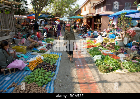 Una donna Lao passeggiando attraverso il cibo fresco di giornata mercato in Luang Prabang Laos Foto Stock