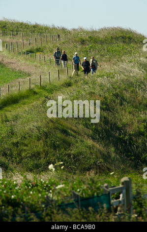 Walkers sul sentiero costiero tra Dunseverick Castello e il Giants Causeway, County Antrim Irlanda del Nord Foto Stock