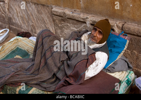 Un senzatetto si trova nella strada a un materasso e coperto con una coperta, Ahmedabad City, nello Stato di Gujarat, India Foto Stock