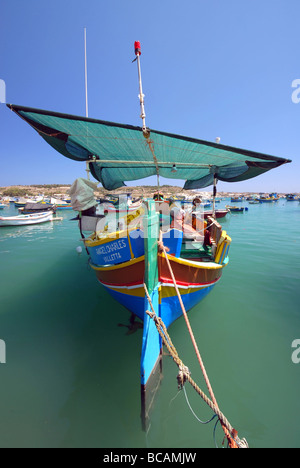 Luzzu maltese nel tradizionale villaggio di pescatori di Marsaxlokk nella regione sud orientale dell'isola mediterranea di Malta Foto Stock