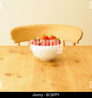 Coppa di fragole su un rustico tavolo da cucina. Foto Stock