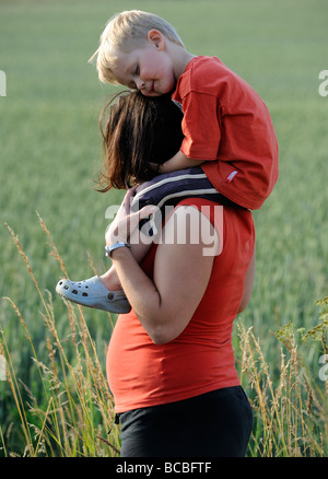 Madre dando figlio Piggyback Ride su prato Foto Stock