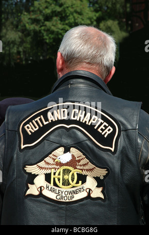 Vista posteriore del ciclista e Harley Davidson proprietario vestita di nero giacca di pelle, Leicestershire, England, Regno Unito Foto Stock