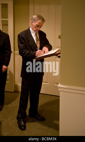 Un nipote del defunto firma il registro degli ospiti a un funerale cattolico home in Stoneham MA Foto Stock