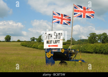 Insegna del negozio agricolo eretta in un campo, svolta a sinistra con le bandiere Union Jack che volano. Campagna rurale inglese Leicestershire Inghilterra anni '2009 2000 Regno Unito Foto Stock