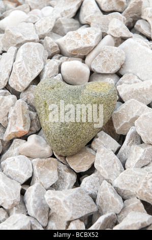 una pietra a forma di cuore sulla riva vicino al mare Foto Stock