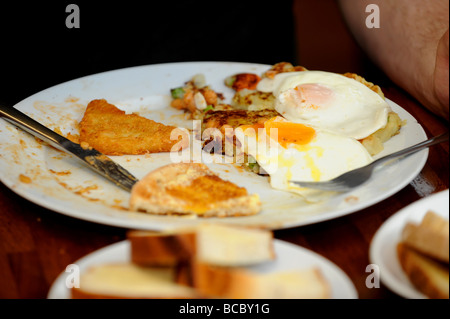 Un uomo le lotte per terminare un gigante la completa prima colazione inglese Foto Stock