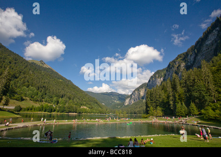 Bagnanti godendo il sole presso la piscina presso il Lac de Montriond nelle Alpi francesi Foto Stock