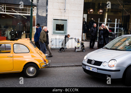 Ragazzo spingere un passeggino sul Laugavegur shopping street Downtown Reykjavík Islanda Foto Stock