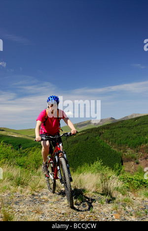 Ciclista foresta Dyfi Powys Galles centrale vista di Cadair Idris Gwynedd North Wales UK Foto Stock