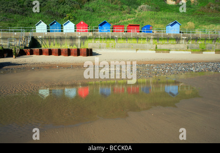 Spiaggia di capanne sul mare muro a Overstrand, Norfolk, Regno Unito, con riflessioni sulla spiaggia. Foto Stock