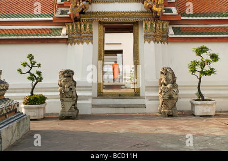 Un monaco buddista solitario che cammina attraverso le porte di Wat Pho Bangkok Thailandia Foto Stock