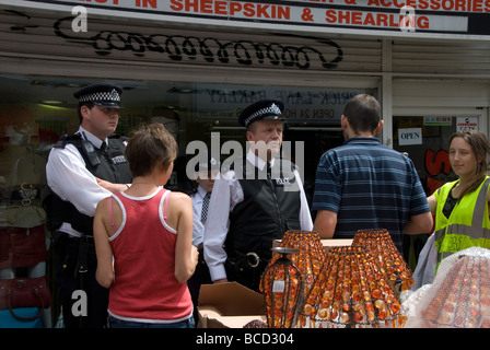 Brick Lane di domenica mattina Anti fur manifestanti picket un negozio di pelle che è sorvegliato dalla polizia Foto Stock