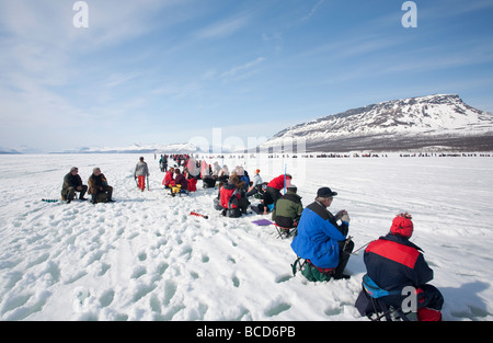 Vana kaksi kalaa ( solo due pesci ) la pesca sul ghiaccio la concorrenza dei concorrenti al Lago di Kilpisjärvi Finlandia Saana fjel in background Foto Stock