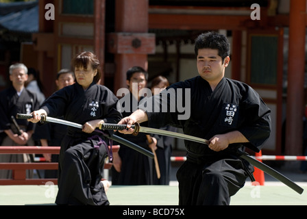 Due persone che usano vere spade di samurai giapponesi durante un esercizio di scherma chiamato kenjutsu o iaido in una manifestazione di arti marziali in Giappone. Foto Stock