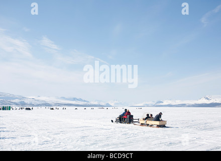 Vana kaksi kalaa ( solo due pesci ) la pesca sul ghiaccio la concorrenza dei concorrenti e la motoslitta al Lago di Kilpisjärvi Lapland Finlandia Foto Stock