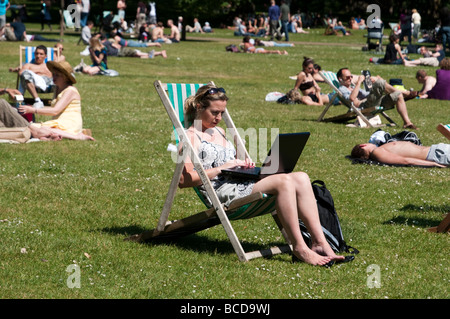 Donna al lavoro su computer portatile in St James Park Londra Inghilterra REGNO UNITO Foto Stock