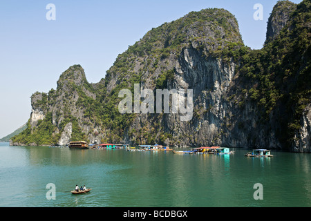 Floating fishermens village al di sotto di alcune delle 3000 carsico calcareo isole nella baia di Halong un patrimonio mondiale meraviglia naturale Foto Stock