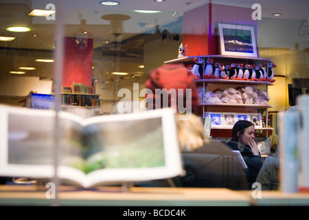 Una ragazza in 'Ida" tourist shop. I puffini giocattoli sul ripiano. Il centro di Reykjavik Islanda Foto Stock