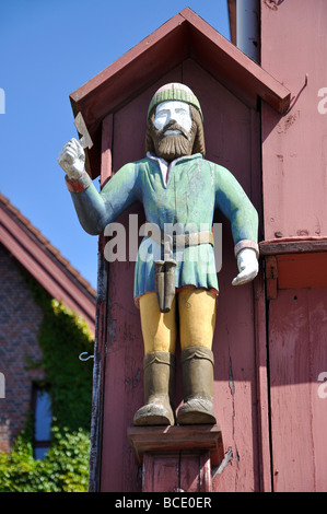 Scolpito statua in legno del XVIII secolo nei magazzini di legno, Bryggen, Bergen Hordaland, Norvegia Foto Stock