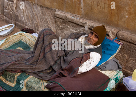 Un senzatetto si trova nella strada a un materasso e coperto con una coperta, Ahmedabad City, nello Stato di Gujarat, India Foto Stock