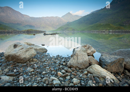 Snowdon nell'alba luce riflessa nella superficie del Llyn Llydaw serbatoio, sul percorso dei minatori, Snowdonia, Galles del Nord, Regno Unito Foto Stock