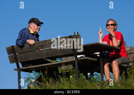 Una coppia di anziani godendo un picnic in estate Foto Stock