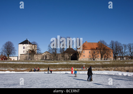 Persone pattinaggio sul laghetto presso il vecchio castello di Nyköping, Svezia Foto Stock