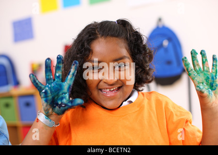 Ragazza in età prescolare con mani coperte di vernice Foto Stock