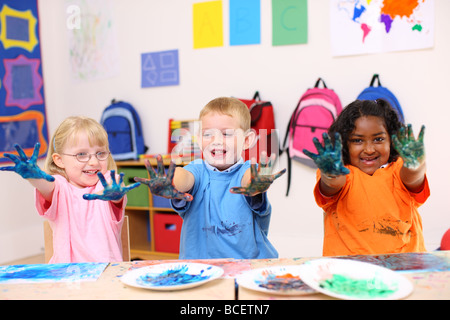 Tre bambini in età prescolare con mani coperte di vernice Foto Stock