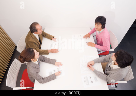 Quattro persone per discutere in sala riunioni Foto Stock
