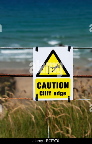 Un segnale di avvertimento sopra le scogliere a Newquay in Cornovaglia,uk Foto Stock