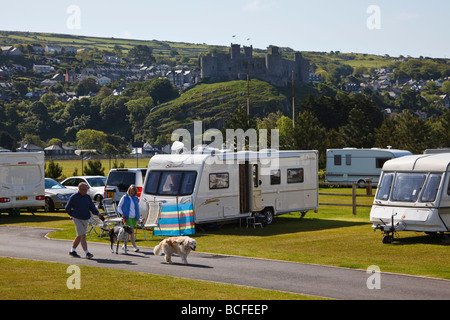 Camper a piedi i loro cani al Min y Don campeggio sotto Harlech Castle, Galles Foto Stock