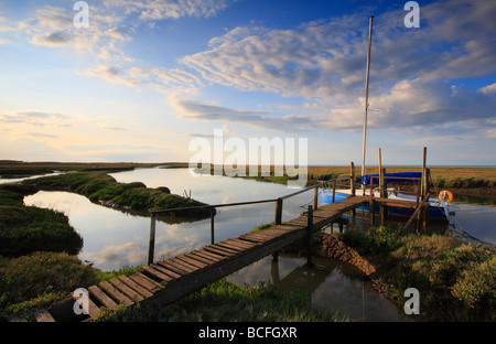 Una vecchia passerella in legno per una barca al porto di Thornham sulla Costa North Norfolk. Foto Stock