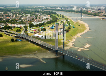 Antenna miniaturizzata vista di Dusseldorf Oberkassel e il fiume Reno. Una fiera del divertimento viene impostato sulle rive del fiume. Foto Stock