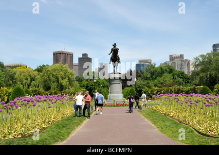 Nei giardini pubblici adiacenti al Boston Common fioritura Alliums gigante che conduce alla statua di George Washington con skyline della città Foto Stock