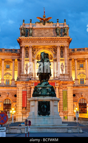 VIENNA, Austria: Il maestoso Palazzo Hofburg brilla alla luce del crepuscolo. L'architettura barocca ornata dell'ex residenza imperiale è illuminata contro il cielo oscuro, riflettendo secoli di potere asburgico nel cuore di Vienna. Foto Stock