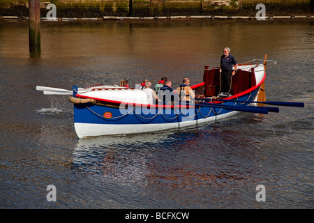 Sei uomini canottaggio un vecchio whitby scialuppa di salvataggio Foto Stock