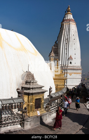 Kathmandu, Nepal. Il nepalese adoratori la filatura Ruote della preghiera a Swayambhunath Temple. Lo zafferano macchie di acqua lo stupa dome. Foto Stock