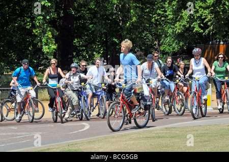 Giornata di sole a Hyde Park, grande gruppo di ciclisti maschi e femmine in tour panoramico con accompagnatore Londra, Inghilterra, Regno Unito Foto Stock