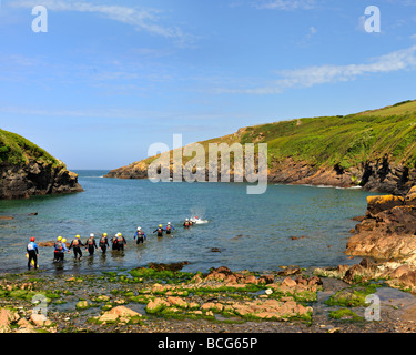 PORT QUIN, CORNWALL, Regno Unito - 13 GIUGNO 2009: Gruppo di persone Coastering in The Cove Foto Stock