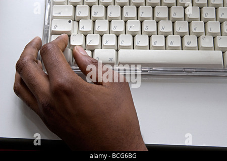 Una mano di un maschio nero lavorando su un Apple Mac tastiera Foto Stock