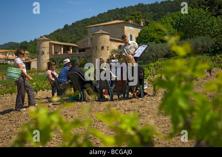 Un gruppo seduto ascoltando un parlare di vinificazione in un vigneto attorno a vini Gigondas denominazione Francia Foto Stock