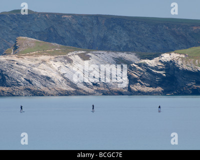 Tre persone in stand up paddle boards attraversando la baia a Newquay Foto Stock