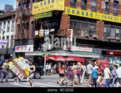 Chinatown, New York. Grand Street, Lower East Side, appartamenti in pietra arenaria. Comunità cinese asiatica. Pedoni che attraversano una strada affollata. STATI UNITI Foto Stock