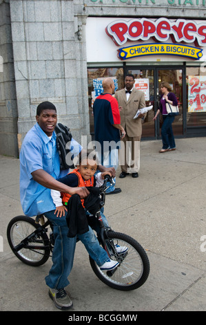Padre e figlia con bicicletta da strada in Chicago, IL, USA, con uomo nero vendere la parola. Foto Stock