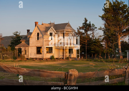 Una vecchia casa Vittoriana nel bisogno di qualche lavoro di ristrutturazione sorge guarda oltre lo stretto di Georgia sul Lummi Island, Washington. Foto Stock