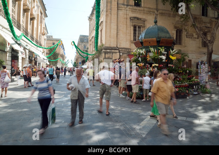 Turisti e popolazione locale a piedi nella Repubblica Street, Valletta, Malta Foto Stock